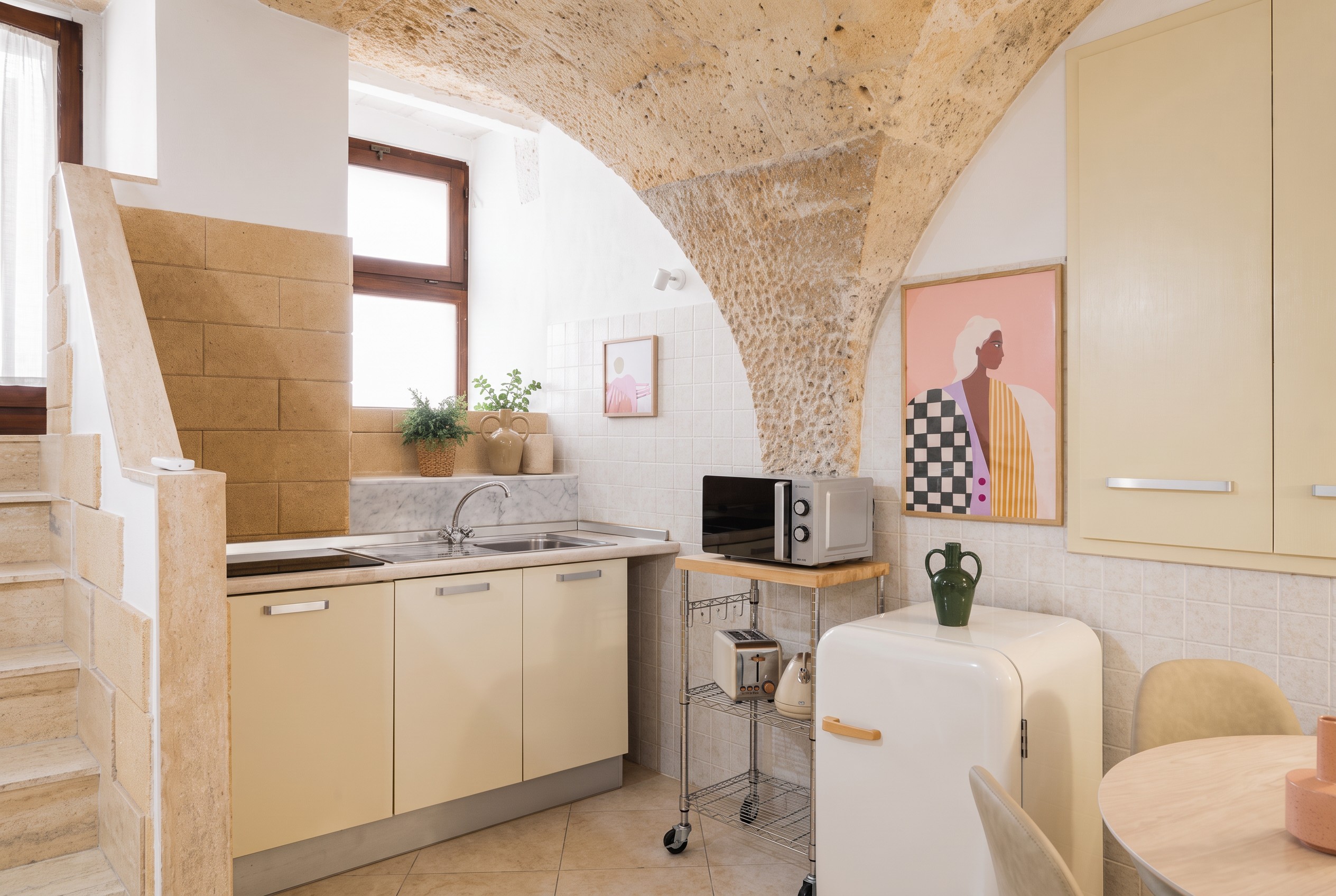 Compact kitchen beneath the apartment's original stone vault