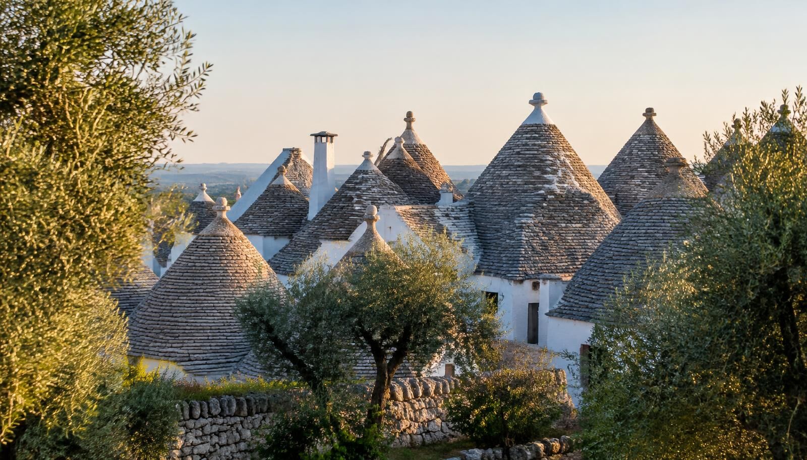 The iconic trulli of Alberobello under a clear blue sky, representative of a classic Puglia itinerary.