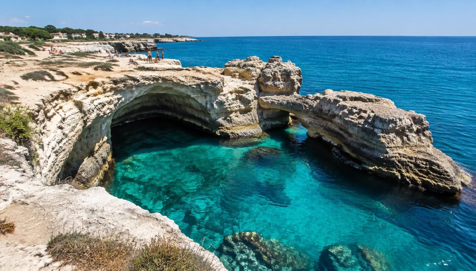 The crystal clear turquoise waters of the Grotta della Poesia natural pool in Roca Vecchia, Puglia.